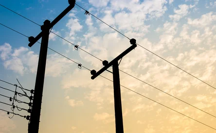 High voltage power pole on the blue sky and cloud close up.