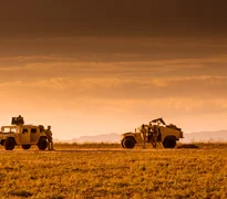 Soldiers marines patrolling on foot and escorted by a Humvee