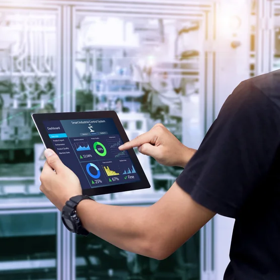 Smart industry control concept.Hands holding tablet on blurred automation machine as background